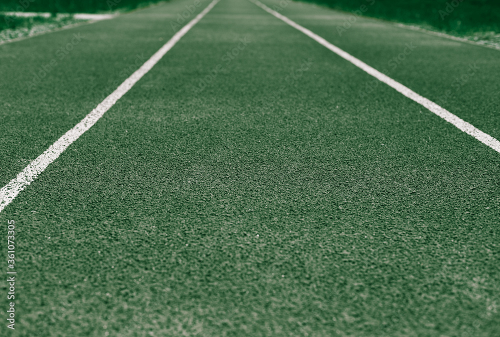 Background of green treadmill, stadium. White lines, stripes
