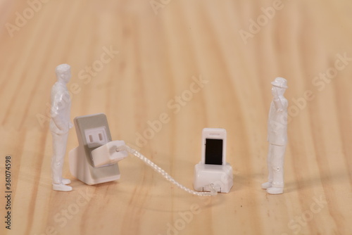 人とスマホ充電のミニチュア	
