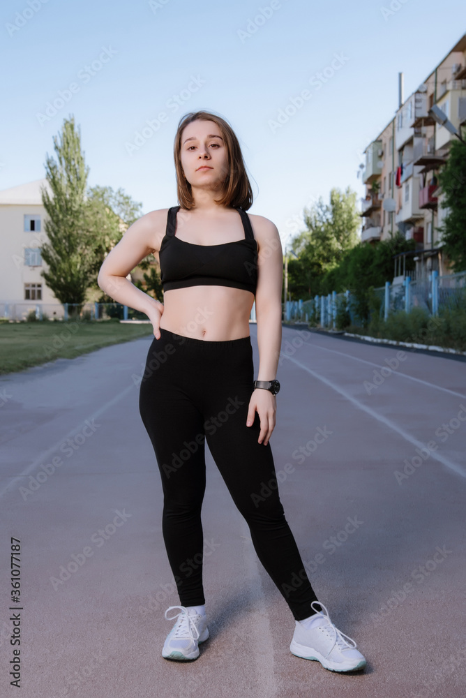 Portrait of attractive sport woman in sportswear posing outdoors at the stadium.