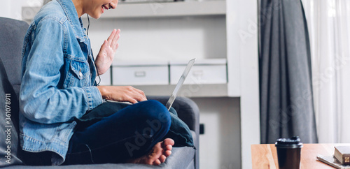 Young smiling happy beautiful asian woman relaxing using laptop computer working and video conference meeting at home.Young creative girl talk with headset.work from home concept