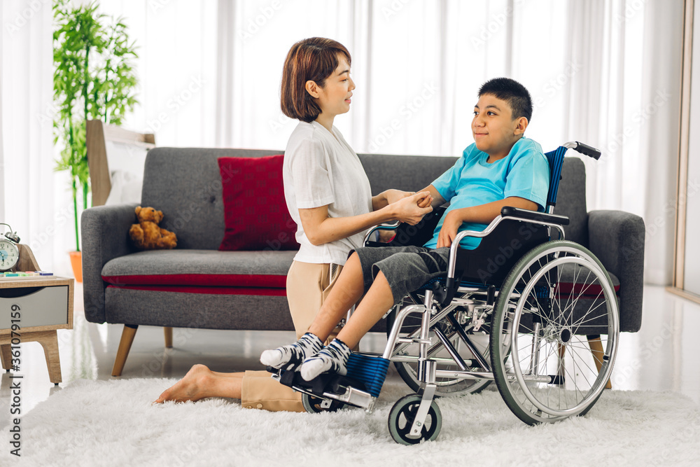 Portrait of asian physiotherapist carer helping and playing with special disabled child health problem by doing exercises sitting in wheelchair in rehabilitation clinic.disability care concept Portrait of asian physiotherapist carer helping and playing with special disabled child health problem by doing exercises sitting in wheelchair in rehabilitation clinic.disability care concept
