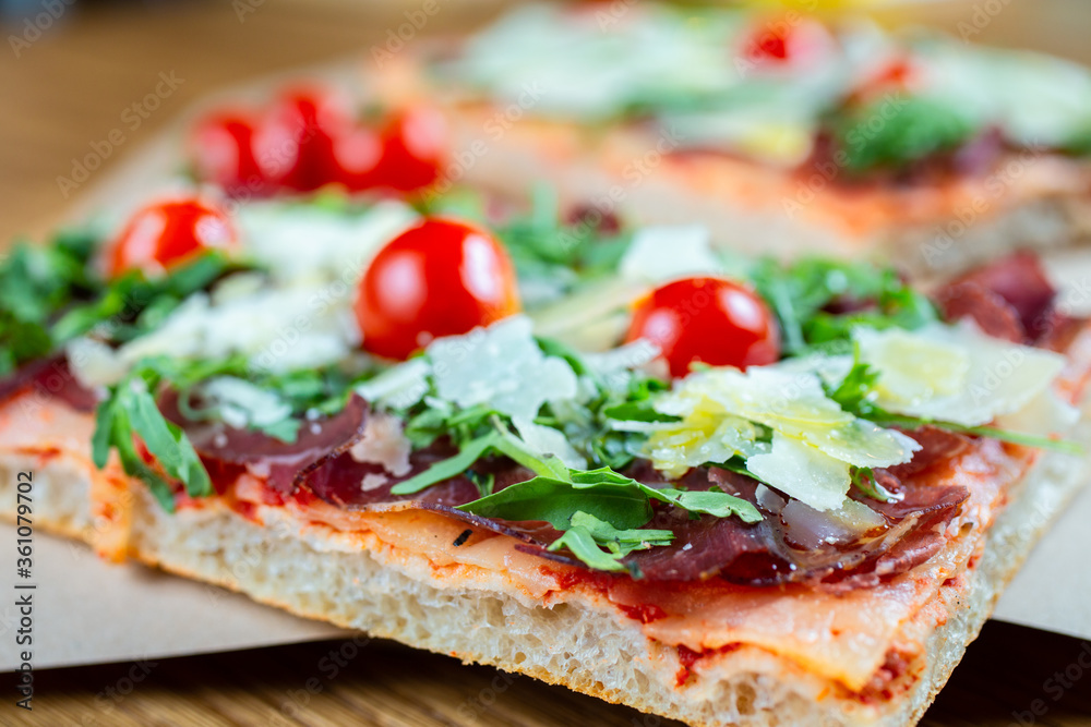 pizza with cherry tomatoes, parmesan cheese, arugula and smoked ham pizza with cherry tomatoes, parmesan cheese, arugula and smoked ham