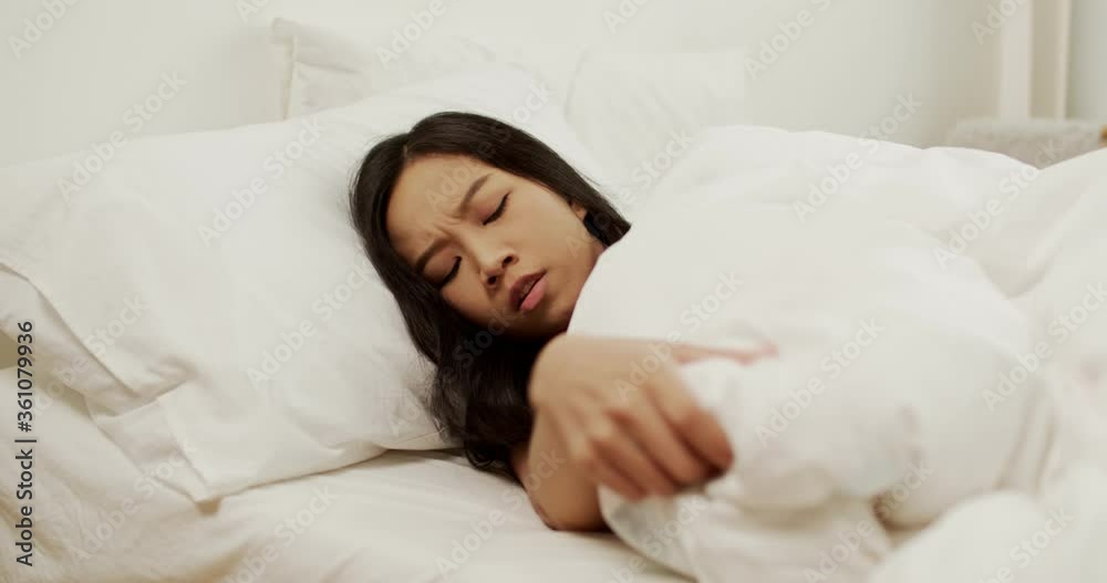 Depressed young Asian Thai woman lay down in bed feel stress anxiety in bedroom, worried mixed-race lady suffer from insomnia in the morning Depressed young Asian Thai woman lay down in bed feel stress anxiety in bedroom, worried mixed-race lady suffer from insomnia in the morning