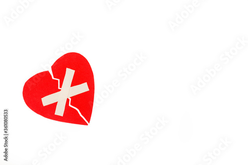 Corazón rojo con vendaje adhesivo sobre un fondo blanco liso y aislado. Vista superior. Copy space photo