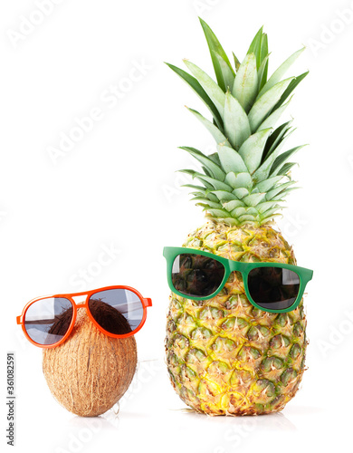 Ripe pineapple and coconut with sunglasses photo