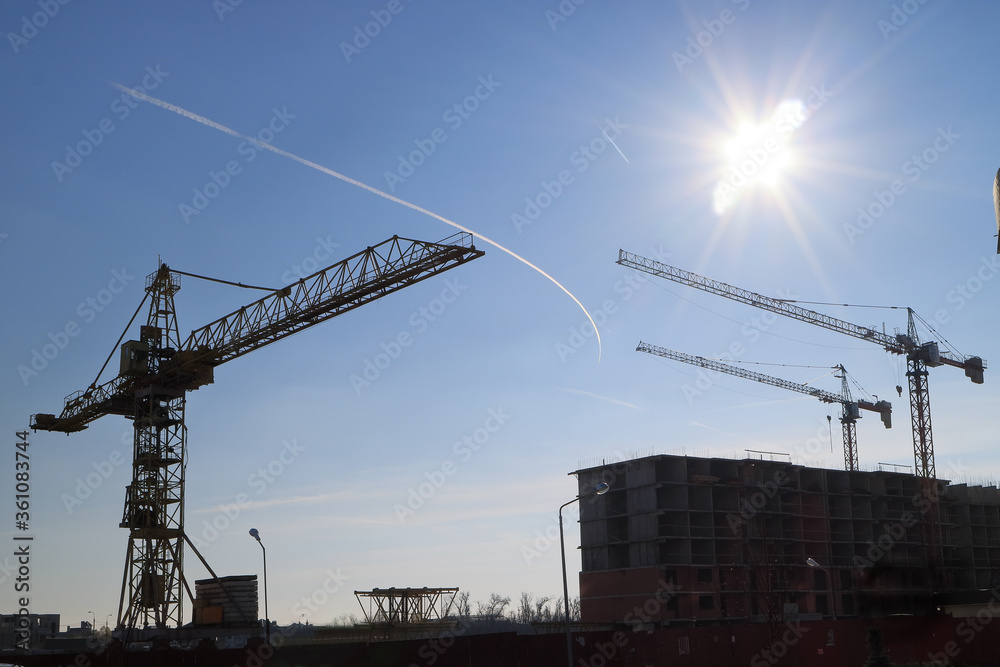 Tower cranes are working on the construction of a new house. Lifting crane. Tower cranes are working on the construction of a new house. Lifting crane.