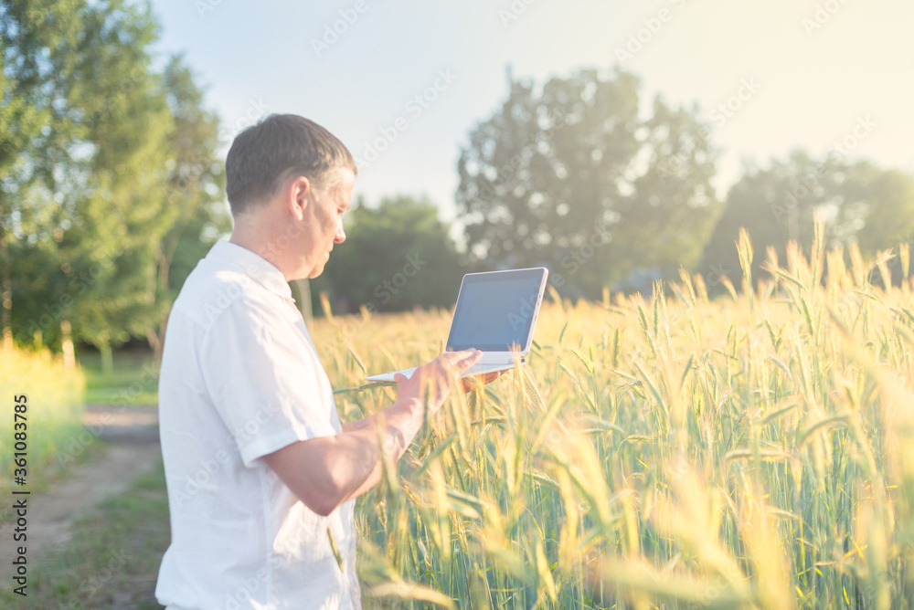 Man working with computer in agroculture field
