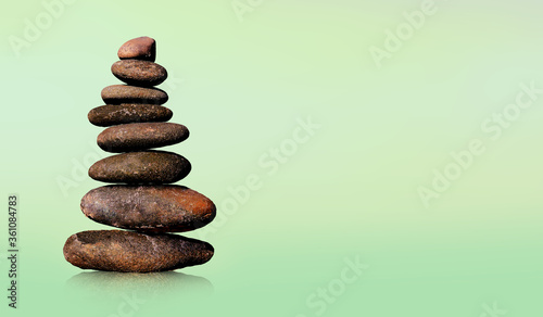 Stone-stacking or rock balancing with green background