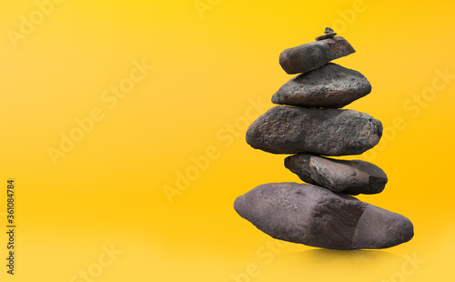Stone-stacking or rock balancing with yellow background