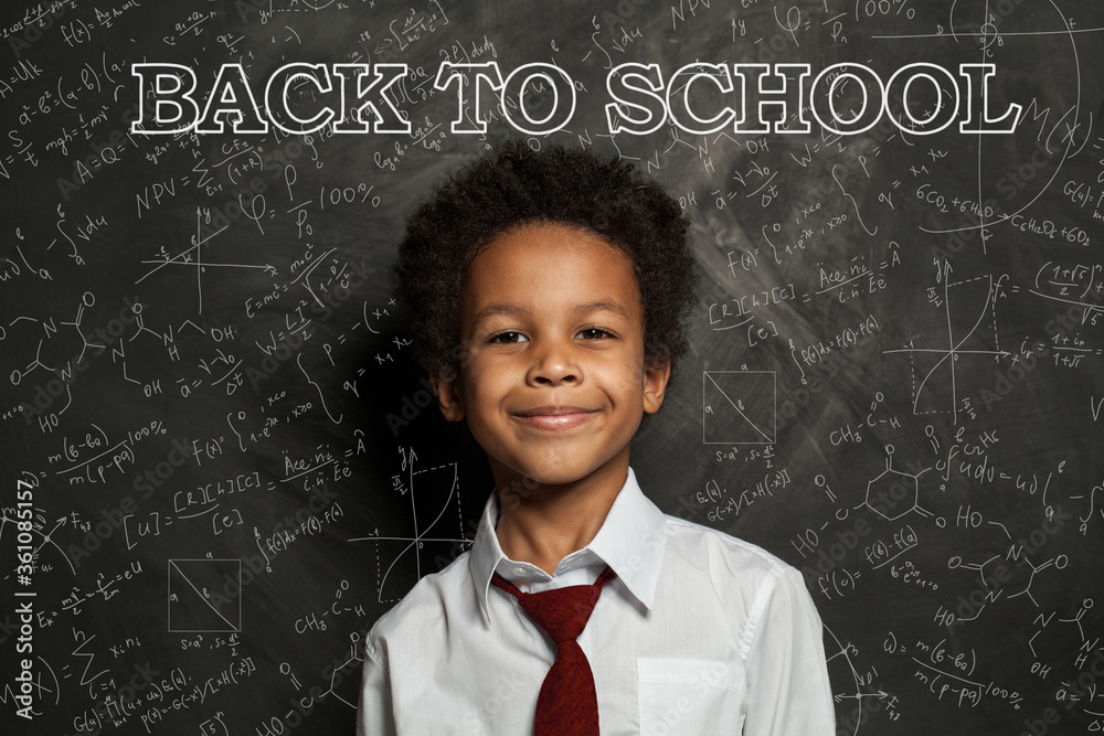 African American school child student on blackboard background with science and maths formulas. Back to school concept African American school child student on blackboard background with science and maths formulas. Back to school concept