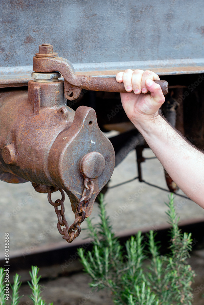 man's arm on old railway coupling piece man's arm on old railway coupling piece