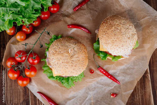 View of fresh tasty burger on wooden table. Food background.