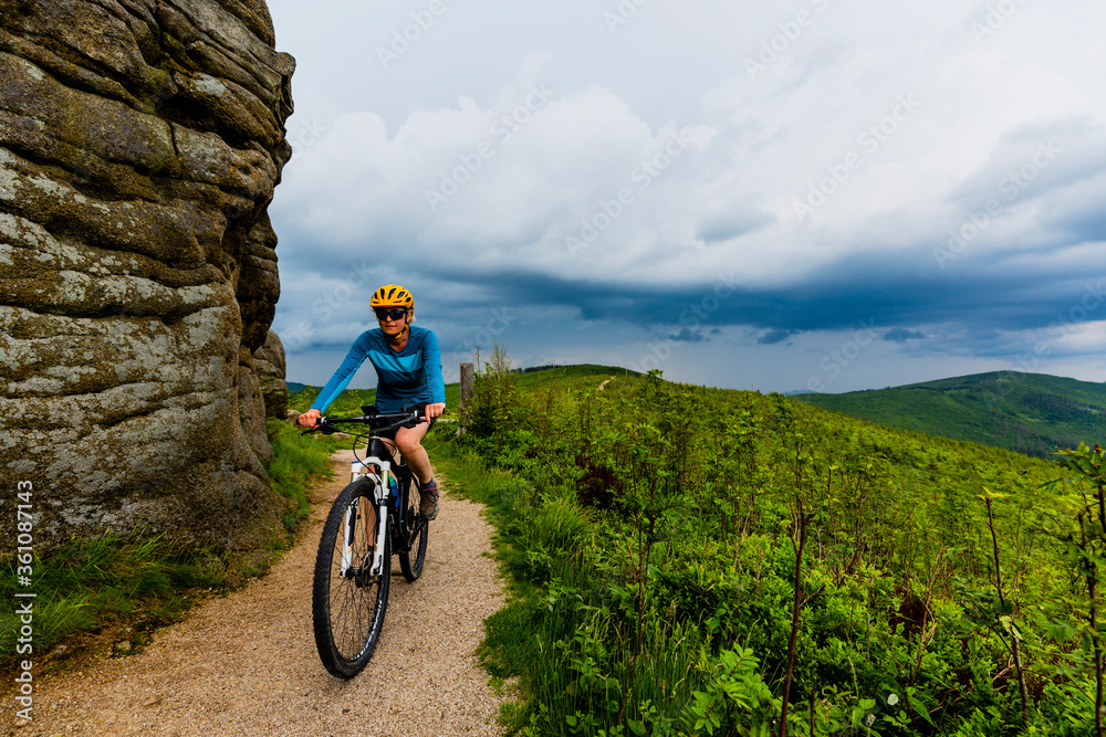 Fototapeta premium Cycling woman on mtb bike on gravel mountain road, Beskidy, Poland.