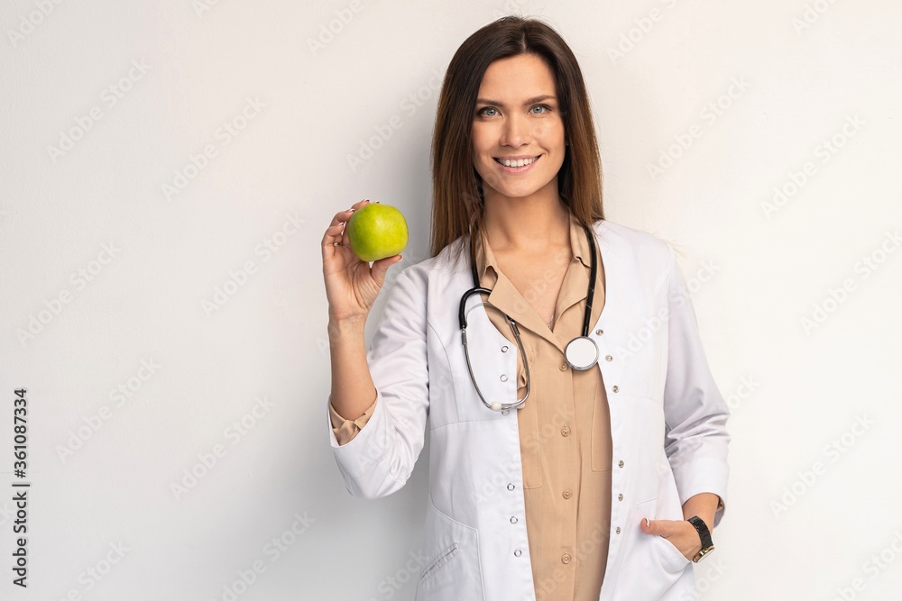 medical doctor woman smile with stethoscope hold dreen fresh apple in hand. Isolated over white background. medical doctor woman smile with stethoscope hold dreen fresh apple in hand. Isolated over white background.