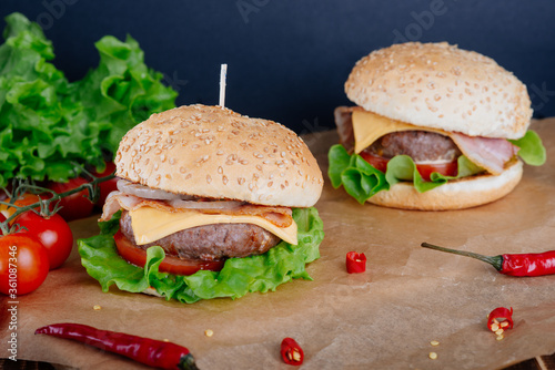 View of fresh tasty burger on wooden table. Food background.