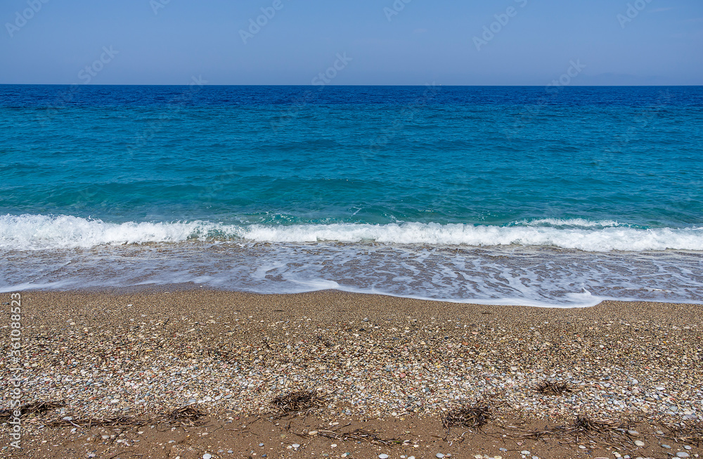 Beautiful stones beach in a sunny day with blue see and sky