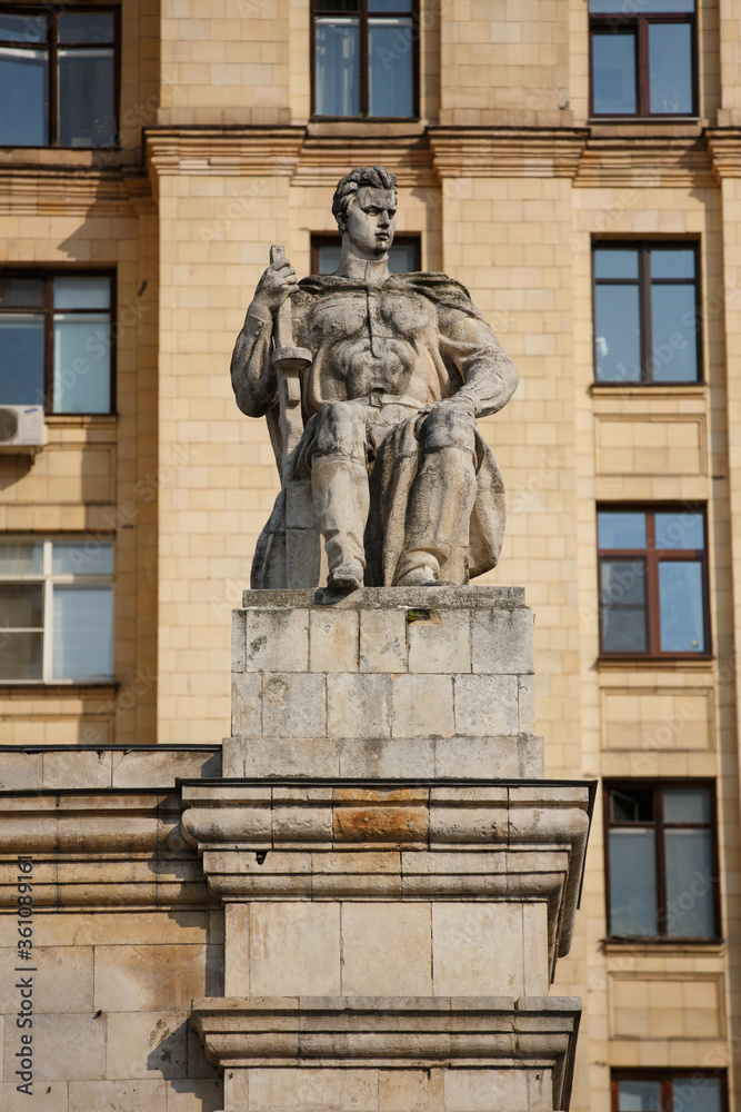 MOSCOW / RUSSIA - 20/04/2019 soviet communist stone sculpture of a strong soldier sitting with a gun (sculptors - Baburin, Nikogosyan, Anikushin). Kudrinskaya Square Building (Aviators' House) facade