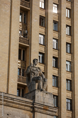 soviet communist stone sculpture of a strong soldier sitting with a gun (sculptors - Baburin, Nikogosyan, Anikushin). Kudrinskaya Square Building (Aviators' House) facade