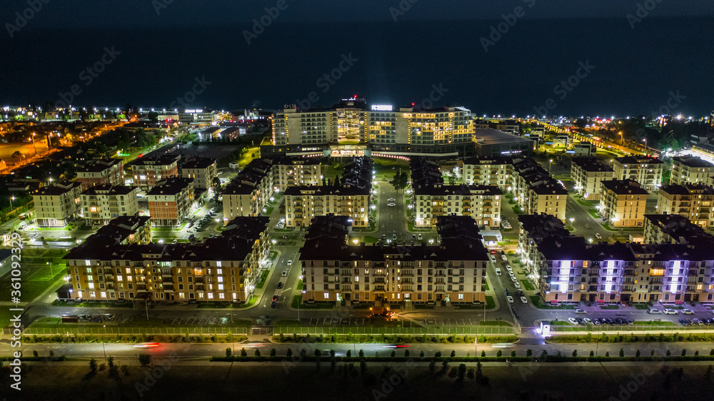 Night city. Evening lighting of the building. Residential area of the city. Sochi Olympic Park. Sunset. Multi-storey building.