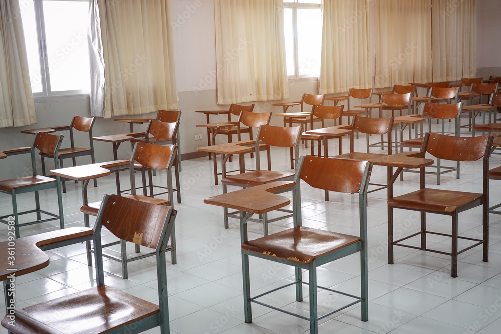 Empty classroom with vintage tone wooden chairs. Classroom arrangement in social distancing concept to prevent COVID-19 pandemic. Back to school concept.	