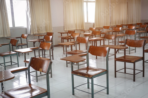 Empty classroom with vintage tone wooden chairs. Classroom arrangement in social distancing concept to prevent COVID-19 pandemic. Back to school concept. 