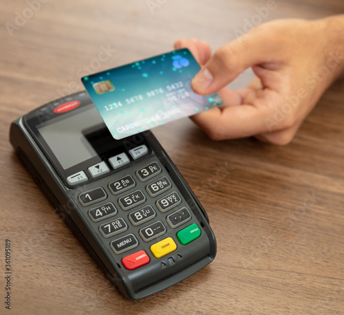 Photo Payment machine, POS terminal and credit card on wooden background