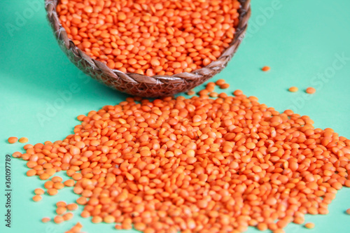 small grains of natural red lentils on a green background