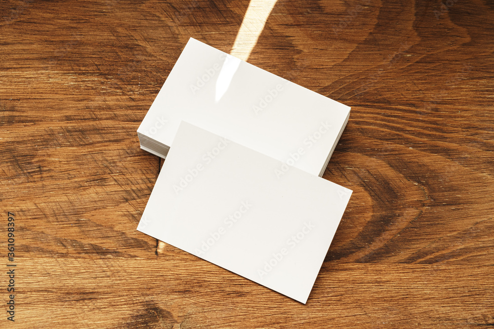 Fototapeta premium Stacks of businesscards with copy space on wooden background