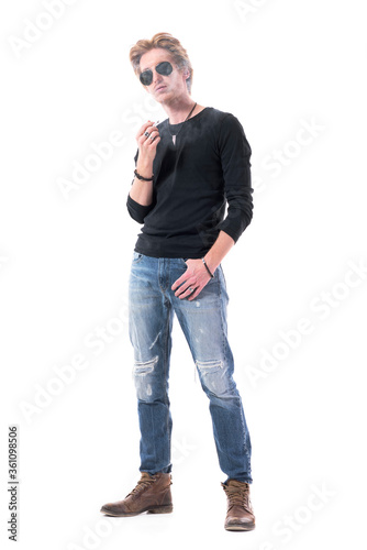 Cool attitude stylish rocker ginger man smoking cigarette blowing and covered in smoke. Full length portrait isolated on white background. 