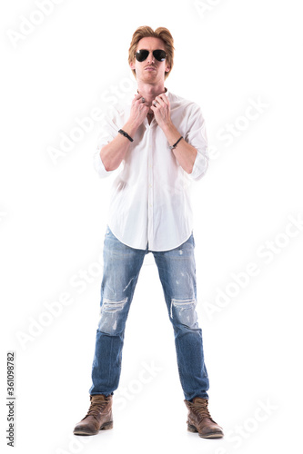 Stylish young handsome ginger man with attitude holding white shirt collar. Full length portrait isolated on white background.  © sharplaninac