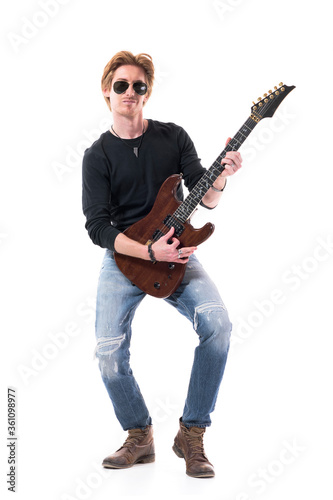 Talented skillful rock music guitarist playing solo on electric guitar wearing sunglasses. Full length portrait isolated on white background. 