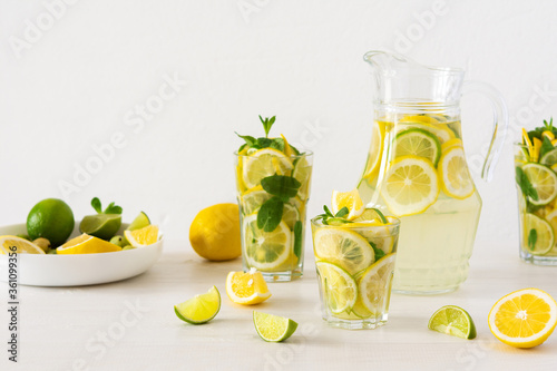 Summer refreshing drink of lemon, lime and mint, jug with lemonade and glasses and citrus slices