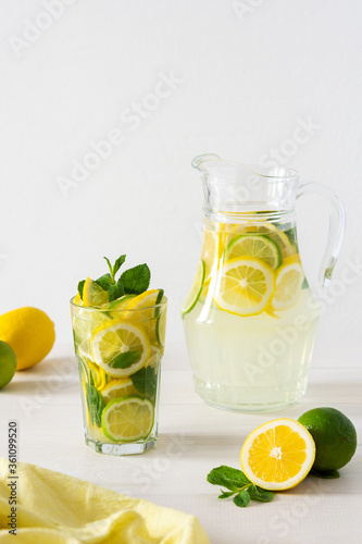 Summer refreshing drink of lemon, lime and mint, jug with lemonade and glasses and citrus slices