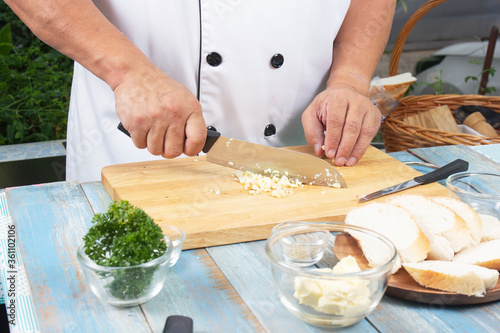 Chef chopping garlic for cooked Garlic bread