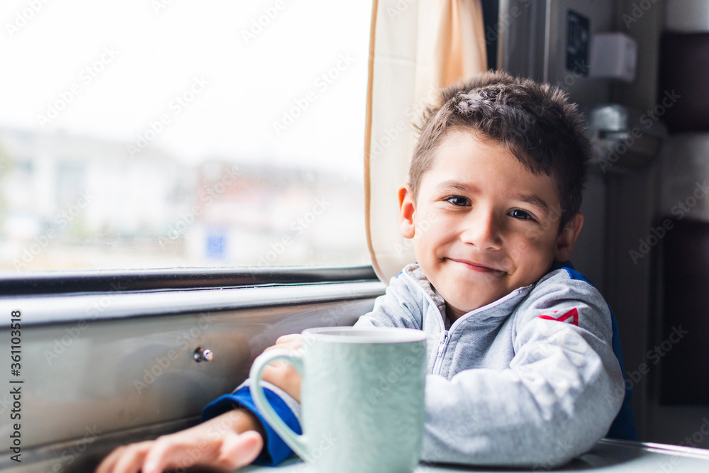 smiling boy is traveling on a train smiling boy is traveling on a train