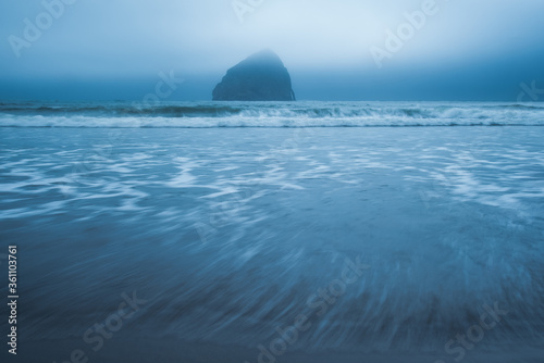 Oregon Coast beach waves and haystack rock on overcast foggy day in Pacific City  Pacific Northwest