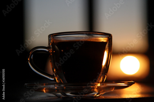 cup of coffee on the table at sunset