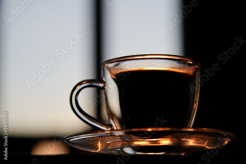 cup of coffee on the table at sunset