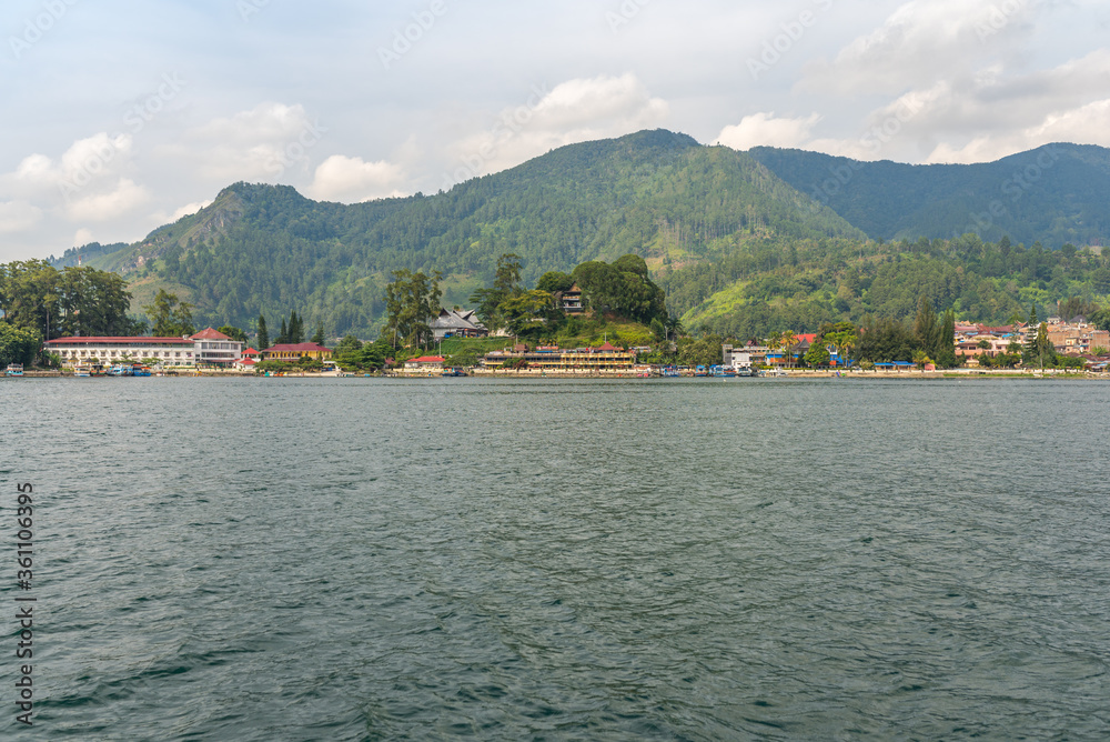Lakeshore of the small town Parapat at the famous Lake Toba, the largest volcanic lake in the world. The town is connecting point and ferry harbor to the island of Samosir