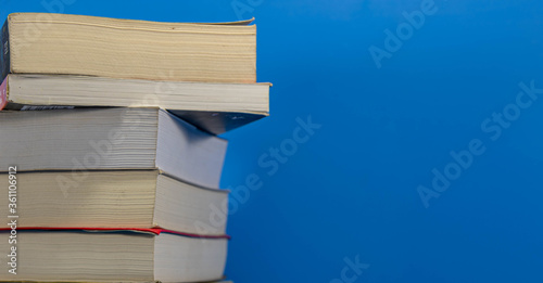 Stack of paper books on blue background