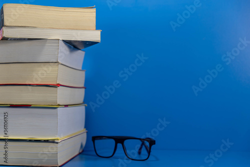 Stack of paper books on blue background