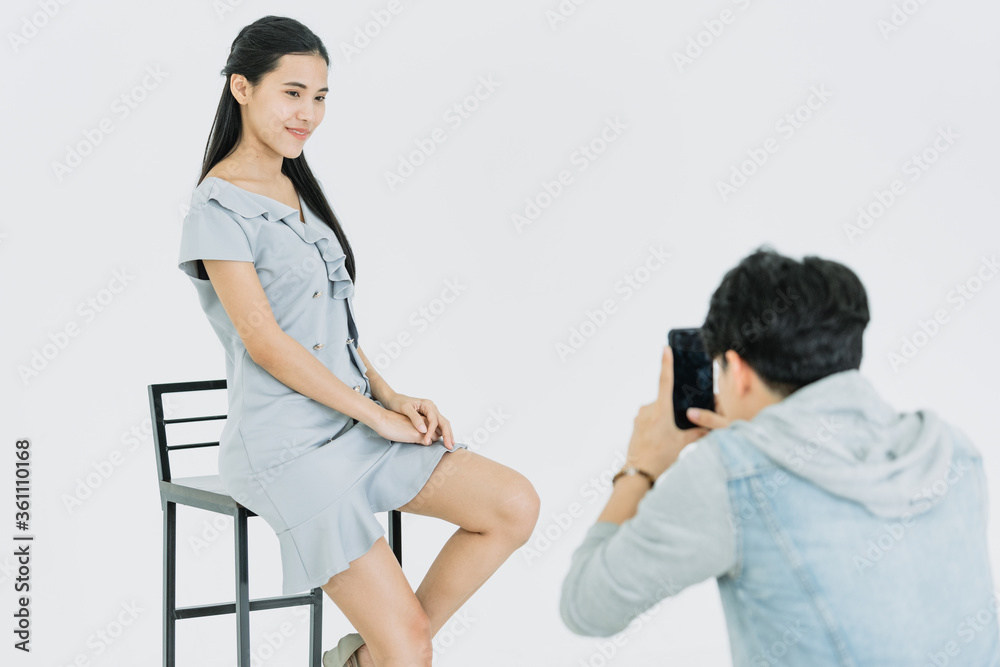 Asian Photographer with smartphone shooting photography with Asian female model in Studio Asian Photographer with smartphone shooting photography with Asian female model in Studio