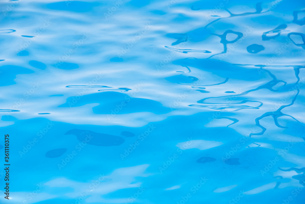 Obraz premium Repeating summer pattern of photographed, living water surfaces in a pool, with the emphasis on light refraction where you can see the sprinkled ground moving along with the waves