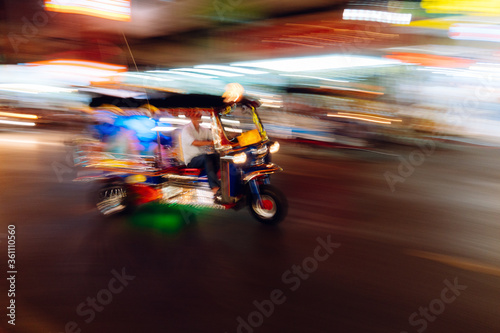 The tuk-tuk is passing by at a blurred speed, blurred images taking pictures with slow shutter speeds.