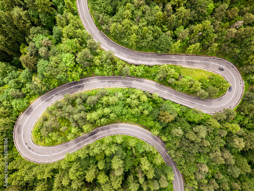 Beautiful aerial view of winding roadmountain cutting through forest landscape in summer time. Aerial view by drone . Romania 