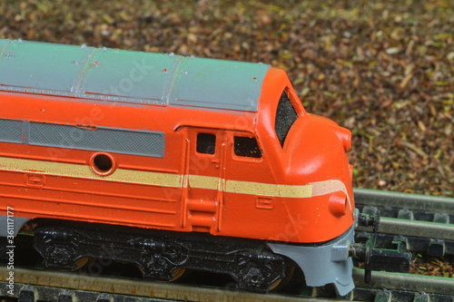 Perfect model of the orange diesel locomotive. Train hobby model on the model railway. Close-up