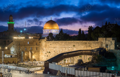 Dramatic purple dawn sky over the Temple Mount and the Western Wall, the holiest place in Judaism, with its plaza divided into sections because of Israeli COVID-19 restrictions on places of worship