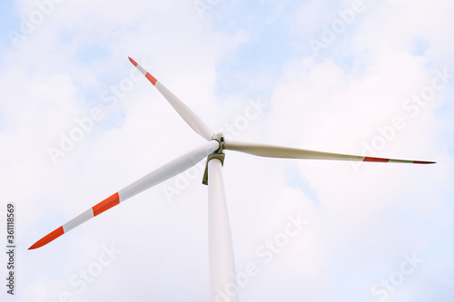 A close-up of the blades of the washed huge wind turbine against the sky.