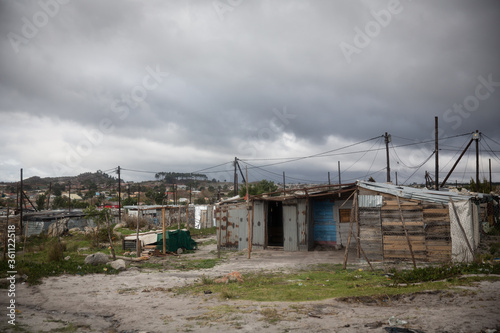 Informal Settlement in a Township with gloomy grey cloud sky in Cape Town South Africa © Mark
