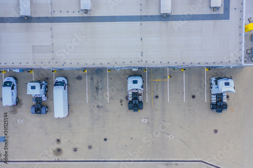 Aerial top view of the large logistics park with warehouse, loading hub with many semi-trailers trucks.